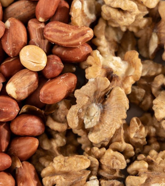 A detailed view of a healthy mix of raw peanuts and walnuts, highlighting texture and variety.